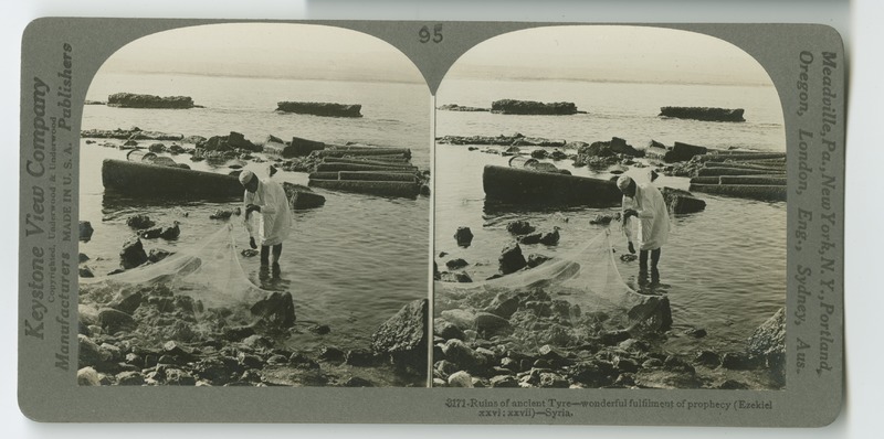 A fisherman with his net beside the partially submerged columns that mark the ancient remnants of the city of Tyre.