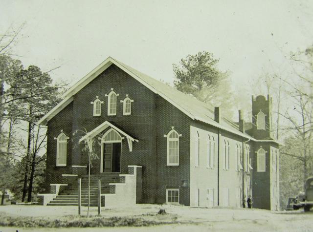 An unidentified church building with a view of the front doors and the bell tower in the back.