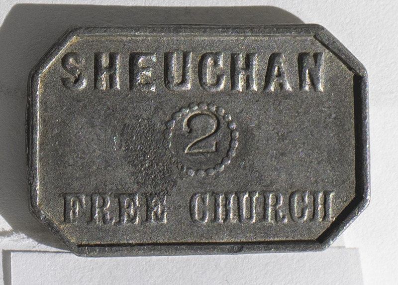 A communion token from Sheuchan Free Church in Sheuchan, Wigtownshire, Scotland. The token is rectangular with inscriptions on the obverse, &quot;Sheuchan 2 Free Church&quot;, and reverse, &quot;This Do in Remembrance of Me&quot;.